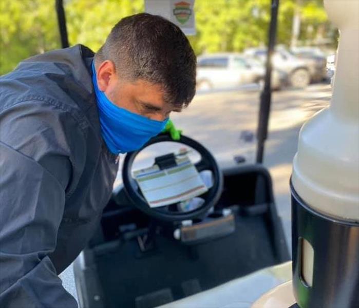 man cleaning golf cart